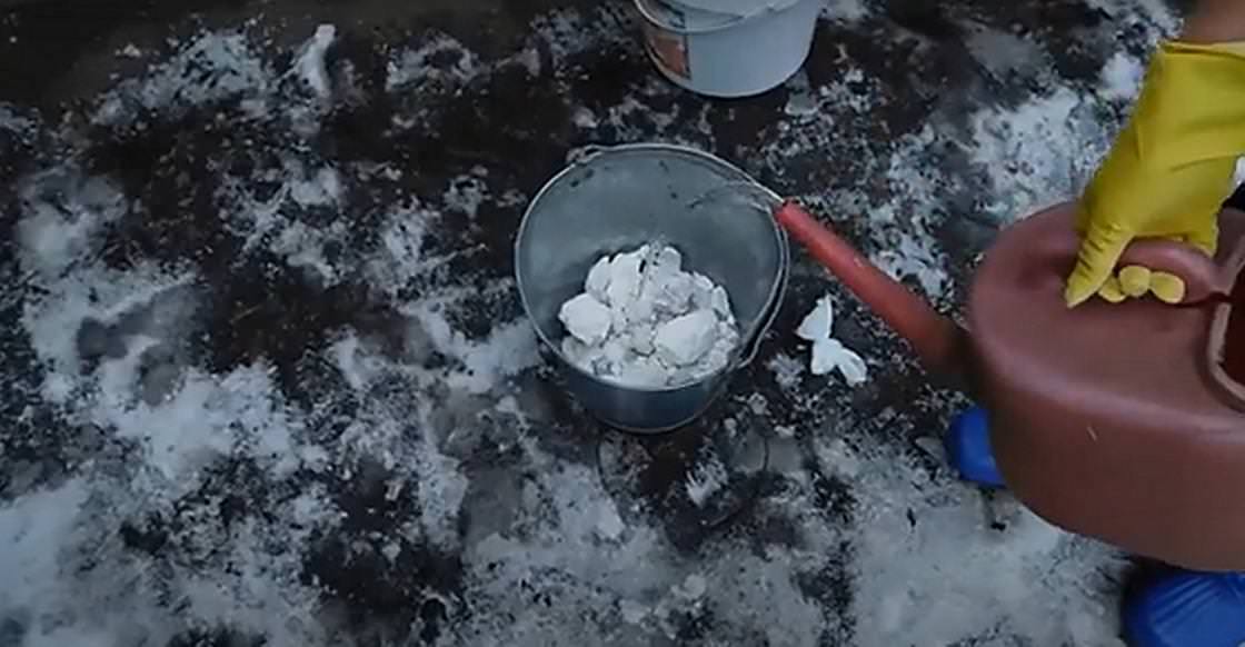 Выливание воды в ведро с известью