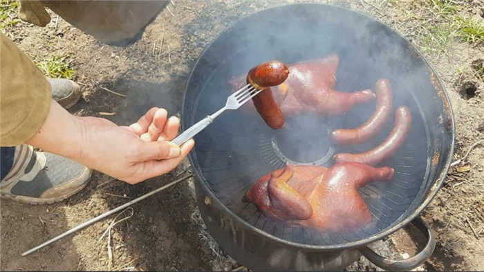 Приготовление копченого мяса в коптильне.