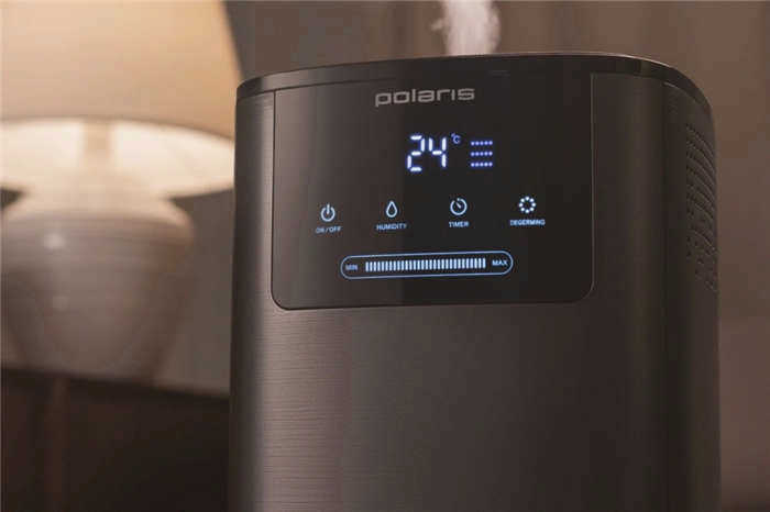 Черный увлажнитель Polaris PUH 8060 TFD стоит перед настольной лампой