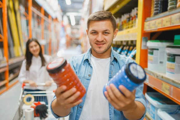 Пара в магазине для строителей ищет краску.