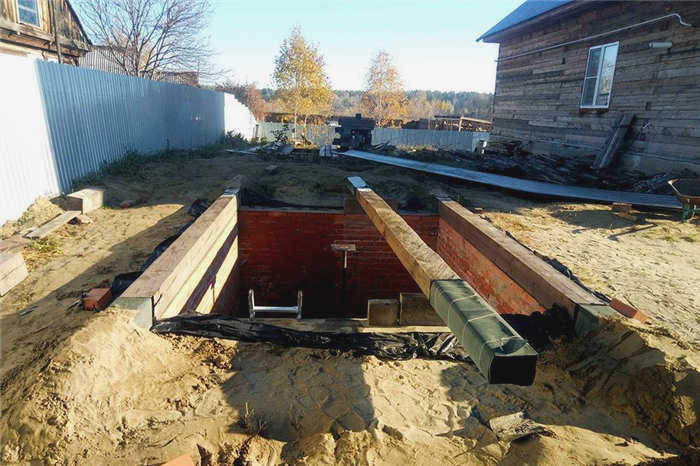 Утро. Справа и слева на фотографии - балки, концы которых зарыты в песок. Это сделано для того, чтобы жаркое сентябрьское солнце не расплавило мастику.