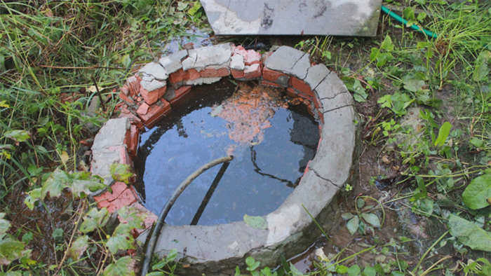 Круглая яма, выложенная кирпичом и заполненная водой.