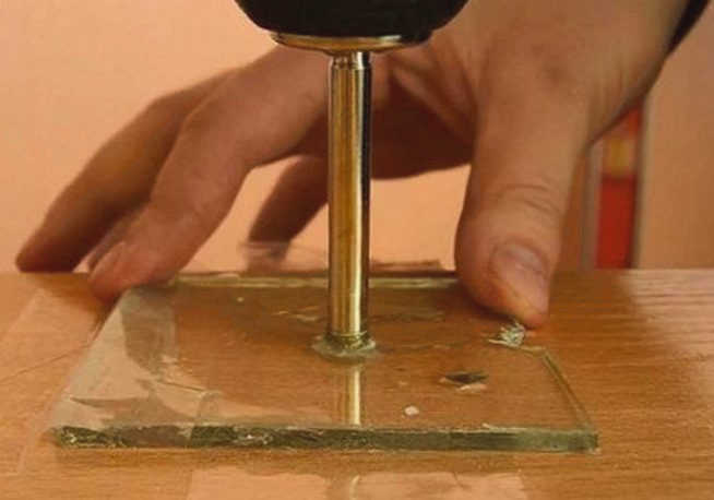 Человек сверлит стекло